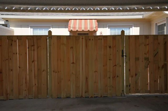a view of a house with small yard plants and palm trees