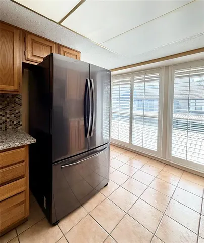 a metallic refrigerator freezer sitting in a kitchen