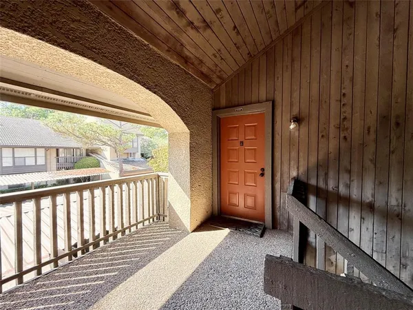 a view of a porch with wooden floor and furniture