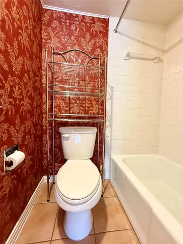 a white toilet sitting next to a bath tub and a shower