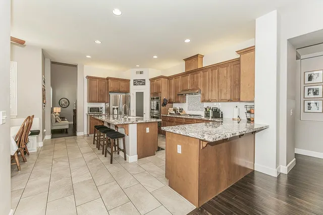 a kitchen with stainless steel appliances granite countertop a sink stove and refrigerator