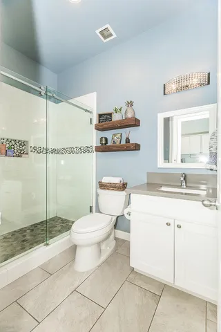 a bedroom with a bed and dresser with wooden floor