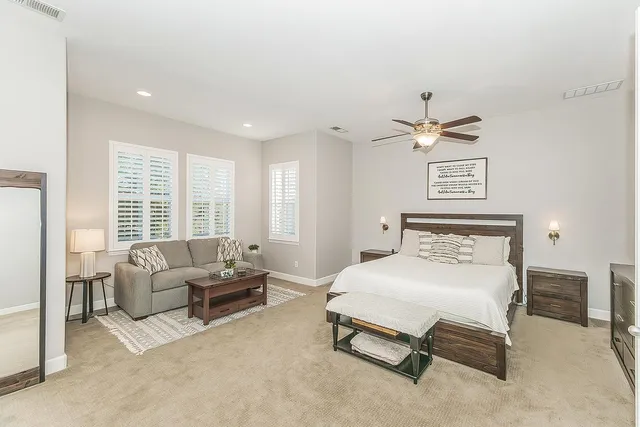 a spacious bedroom with a bed and a chandelier