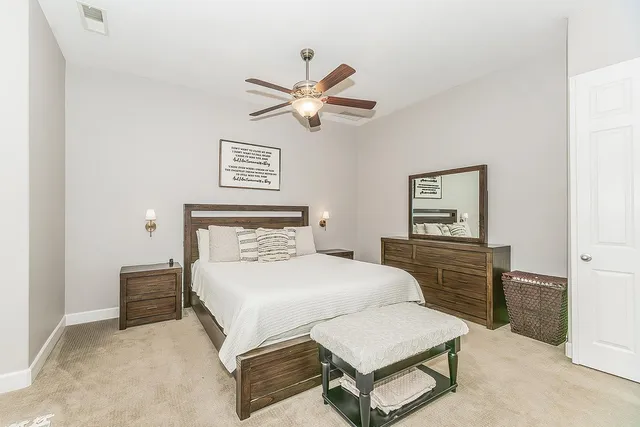 a spacious bathroom with a granite countertop double vanity sink a mirror and a bathtub