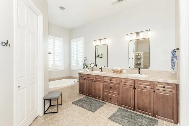 a spacious bathroom with a double vanity sink and mirror