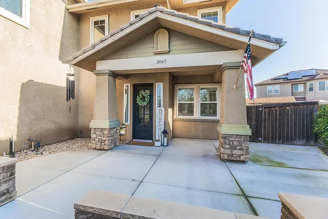 a dining room with wooden floor a chandelier a glass table and chairs