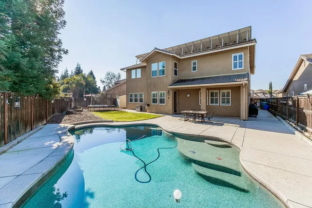 a view of a house with backyard and sitting area