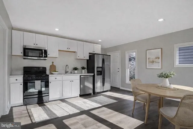 a kitchen with stainless steel appliances kitchen island granite countertop a refrigerator and a stove top oven