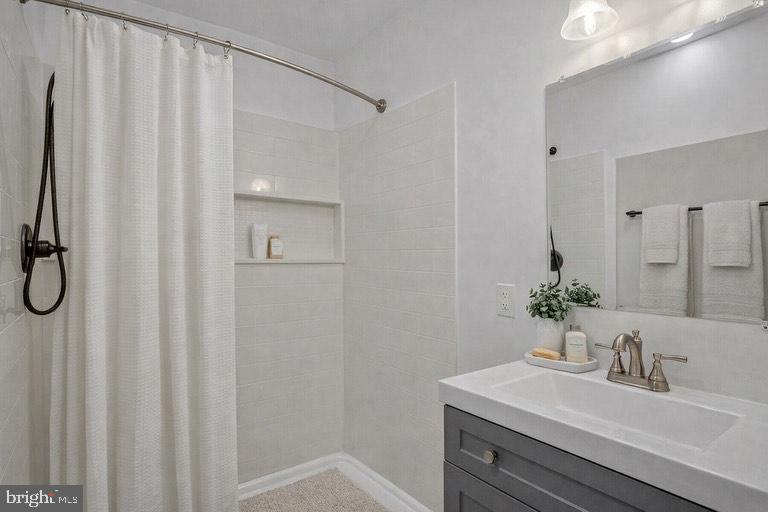 1633 Shadyside Drive Edgewater, MD 21037 - Photo 10 of 12 a bathroom with a sink a mirror and a shower