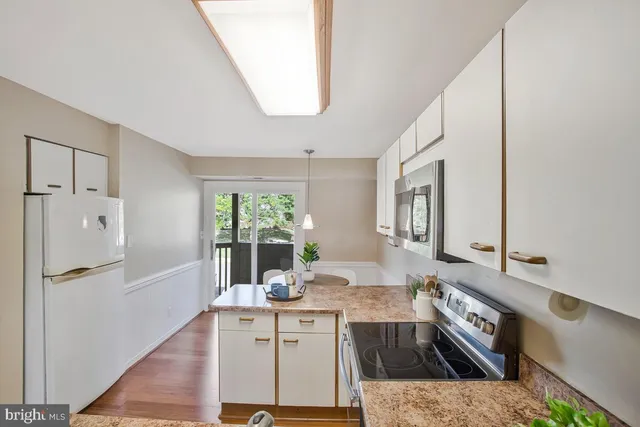 a kitchen with stainless steel appliances granite countertop a sink and a refrigerator