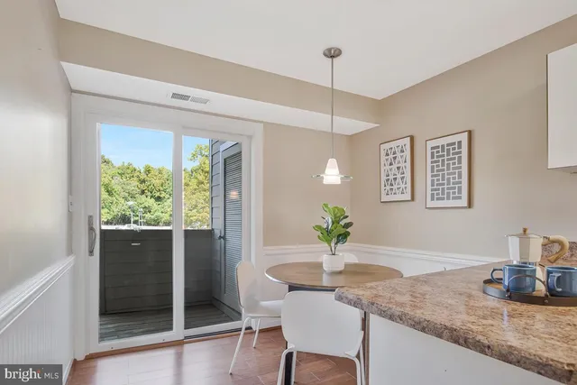 a kitchen with stainless steel appliances granite countertop a refrigerator a stove a kitchen island with a dining table and chairs