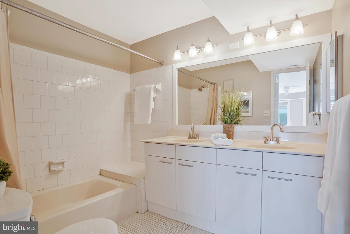 7002 Channel Village Court, Unit 101 Annapolis, MD 21403 - Photo 17 of 57 a bathroom with a granite countertop sink mirror and bathtub