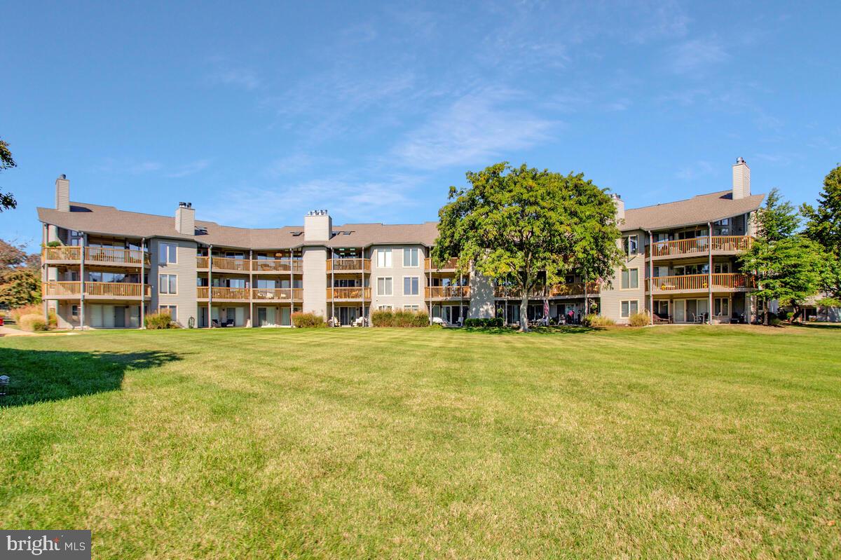 7002 Channel Village Court, Unit 101 Annapolis, MD 21403 - Photo 33 of 57 a front view of a building with a garden