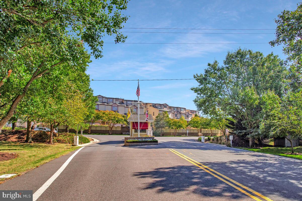 7002 Channel Village Court, Unit 101 Annapolis, MD 21403 - Photo 44 of 57 a view of a street with a building and trees in the background