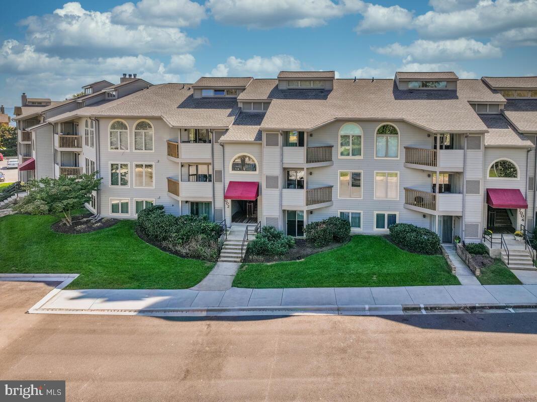 7002 Channel Village Court, Unit 101 Annapolis, MD 21403 - Photo 50 of 57 a front view of multiple houses with yard