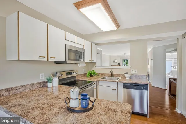 a kitchen with stainless steel appliances granite countertop a sink stove and cabinets