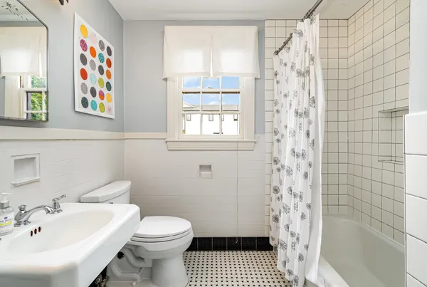 a bathroom with a sink a toilet and shower curtain