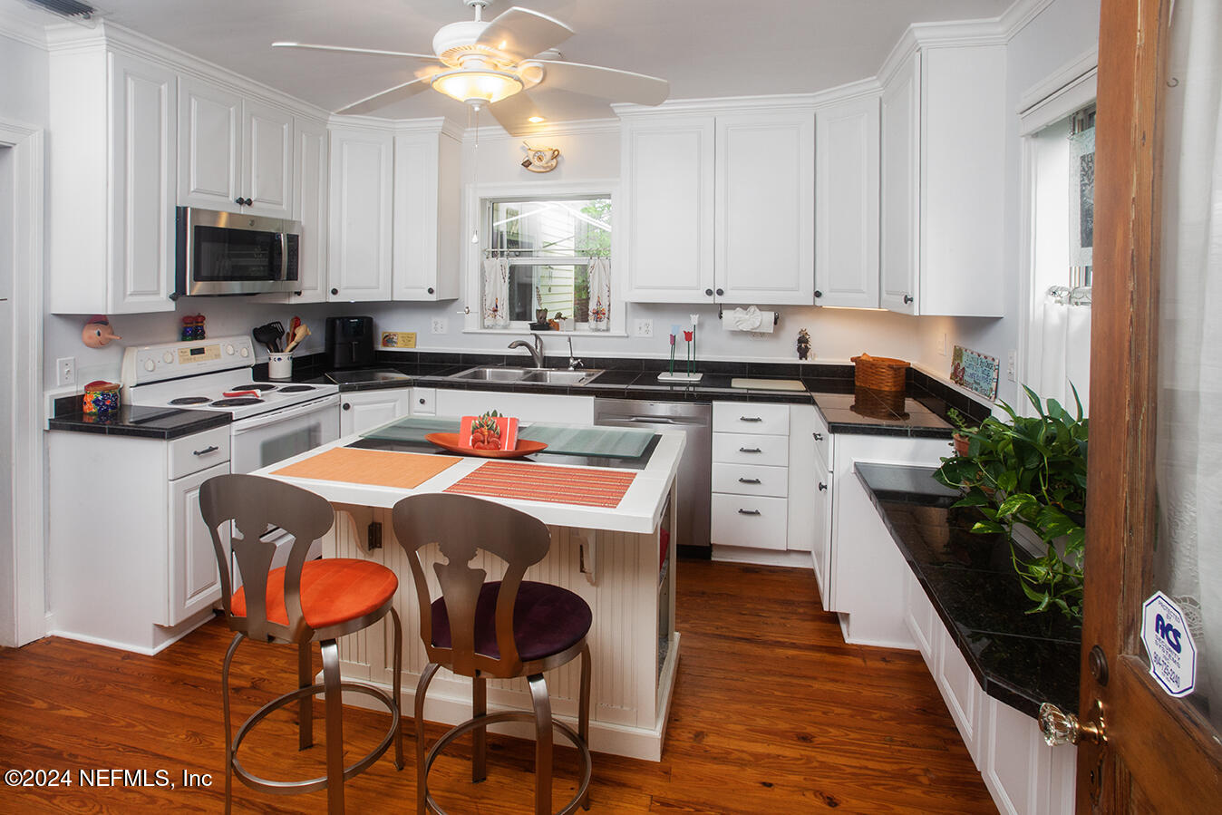 1117 Old Hickory Road Jacksonville, FL 32207 - Photo 7 of 14 a kitchen with stainless steel appliances granite countertop a stove top oven a sink dishwasher and white cabinets with wooden floor