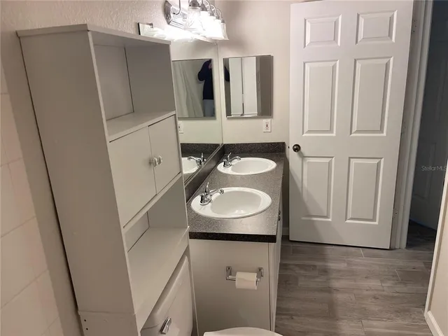 a bathroom with a sink a toilet and mirror