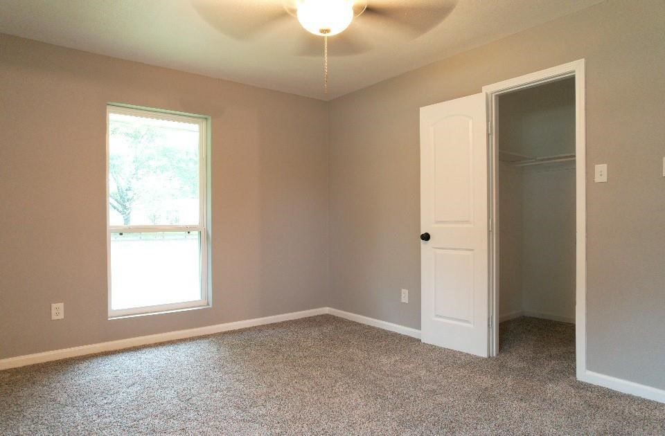 25373 Goodson Road Splendora, TX 77372 - Photo 18 of 41 Room with a ceiling fan, door, and laminate/wood flooring—versatile and ready for personalization.