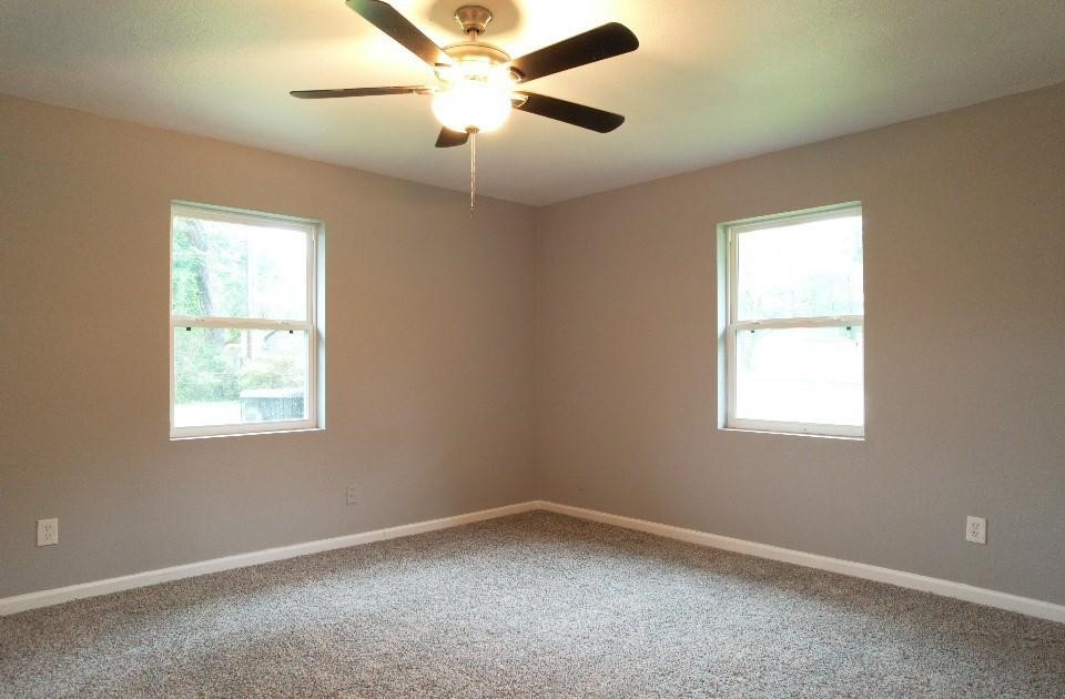 25373 Goodson Road Splendora, TX 77372 - Photo 22 of 41 Cozy room with a ceiling fan, large windows, and stylish plaster finish—perfect for relaxing.