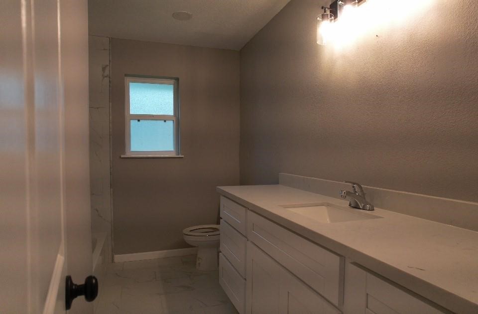 25373 Goodson Road Splendora, TX 77372 - Photo 31 of 41 Modern bathroom with a sleek sink, toilet, and stylish tiles—functional and stylish for any home.