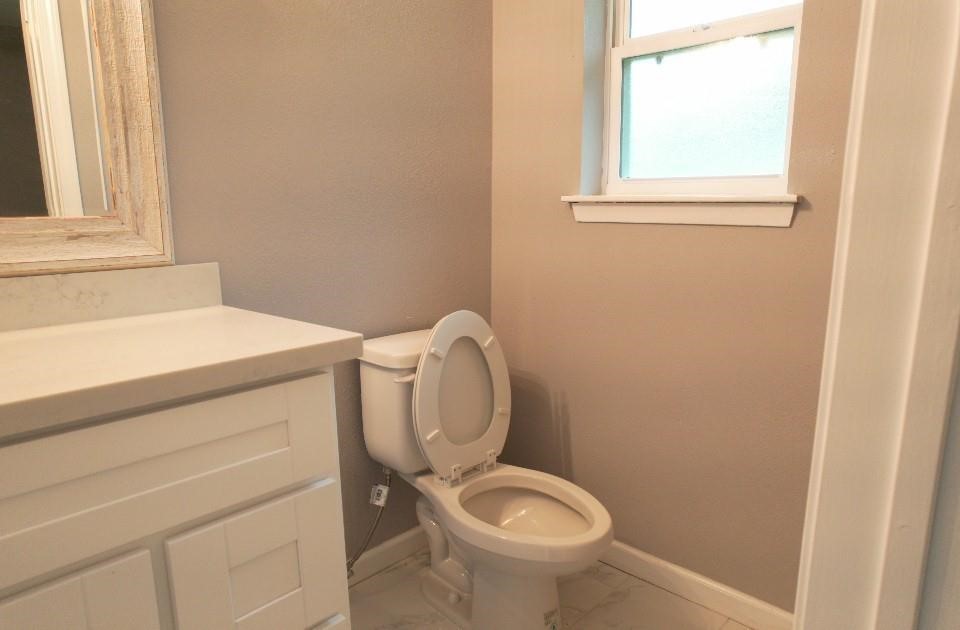 25373 Goodson Road Splendora, TX 77372 - Photo 32 of 41 Bathroom with a toilet, sink, mirror, and modern tiles—bright and inviting.