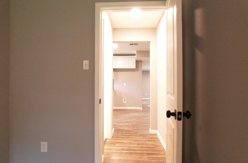 25373 Goodson Road Splendora, TX 77372 - Photo 37 of 41 Hallway with wood flooring, stylish molding, and a modern door handle—warm and inviting.