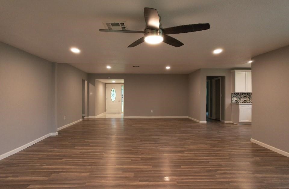 25373 Goodson Road Splendora, TX 77372 - Photo 10 of 41 Spacious room with a ceiling fan, wood laminate flooring, and a warm, inviting feel.