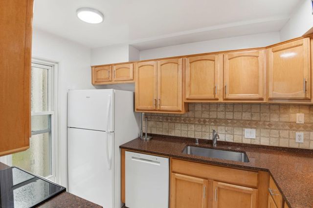 a kitchen with a refrigerator sink and cabinets