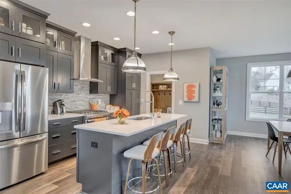 a kitchen with stainless steel appliances kitchen island granite countertop a kitchen island and chairs in it