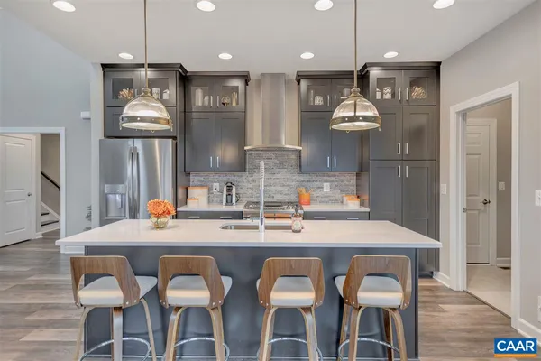 a kitchen with a table chairs refrigerator and wooden floor