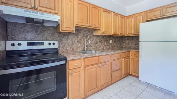a kitchen with stainless steel appliances granite countertop a refrigerator stove and white cabinets