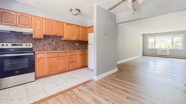 a kitchen with granite countertop wooden floors and white cabinets
