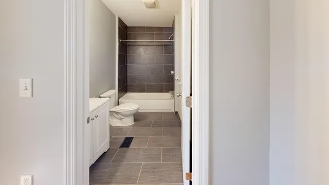 a bathroom with a granite countertop toilet and a shower