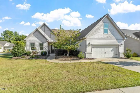a view of a house with a yard and potted plants
