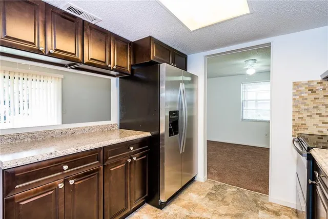 a kitchen with stainless steel appliances granite countertop a refrigerator and a sink