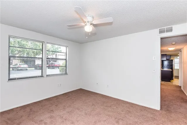 an empty room with a ceiling fan and window