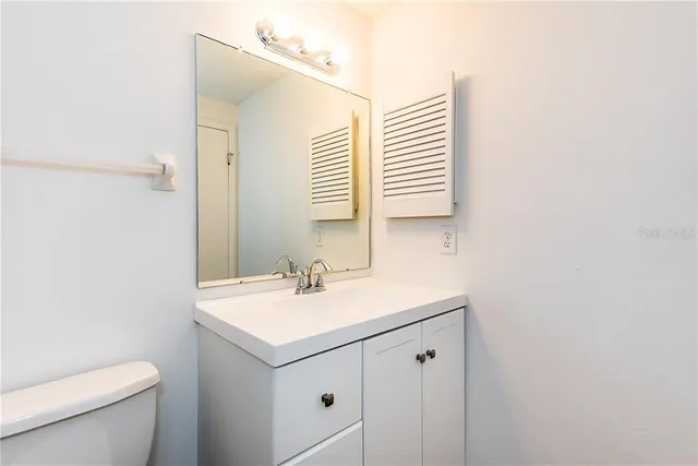 a bathroom with a sink toilet vanity and a mirror