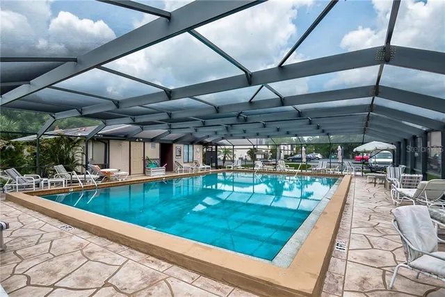 a view of a swimming pool with a patio and a yard