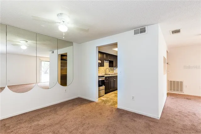 a view of an empty room with cabinet and a window
