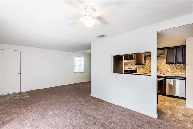 a view of a kitchen with an empty room and kitchen view