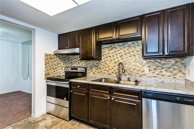 a kitchen with granite countertop stainless steel appliances and cabinets