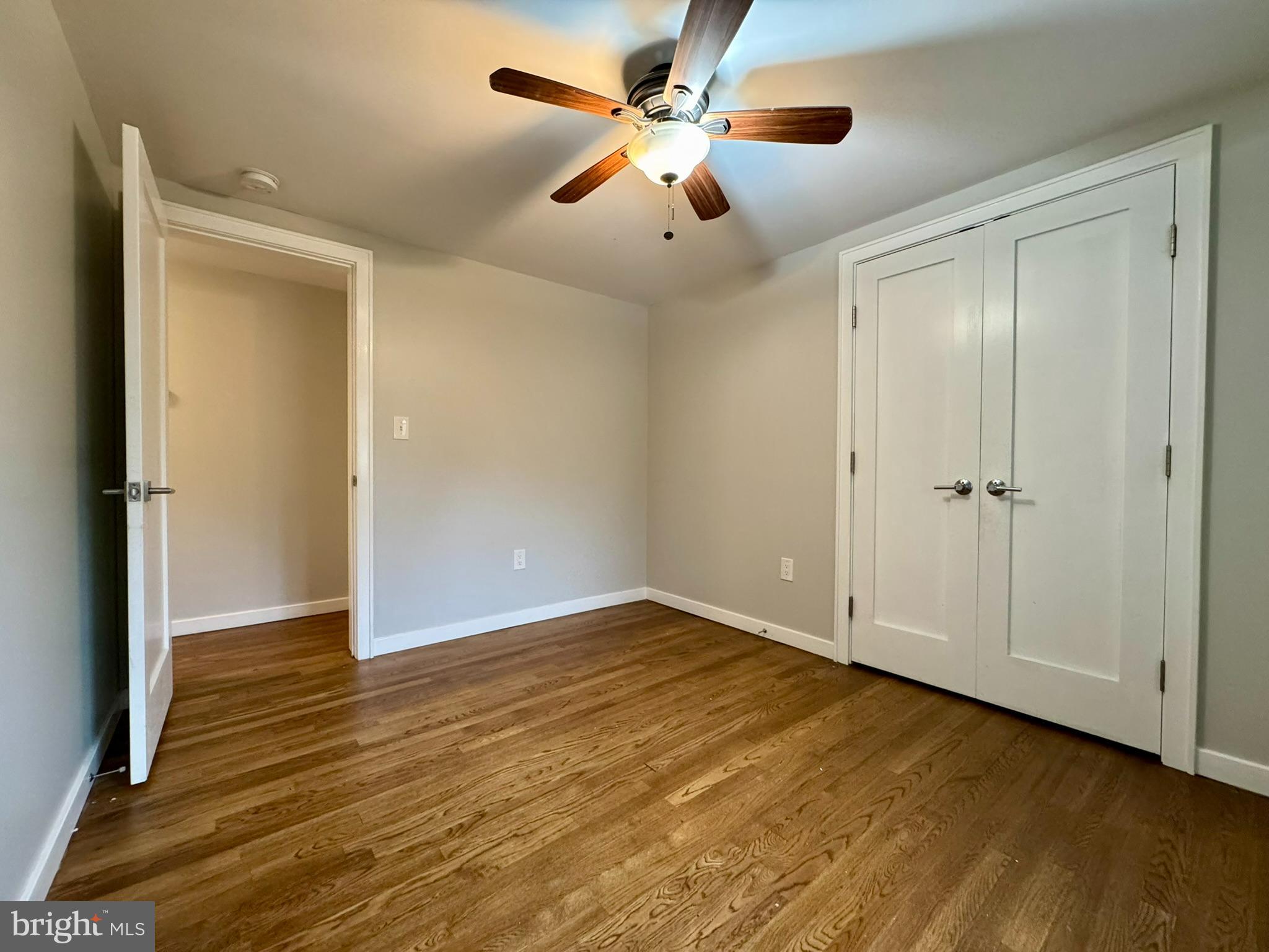9813 Moyer Road Damascus, MD 20872 - Photo 12 of 31 an empty room with wooden floor chandelier fan and closet area