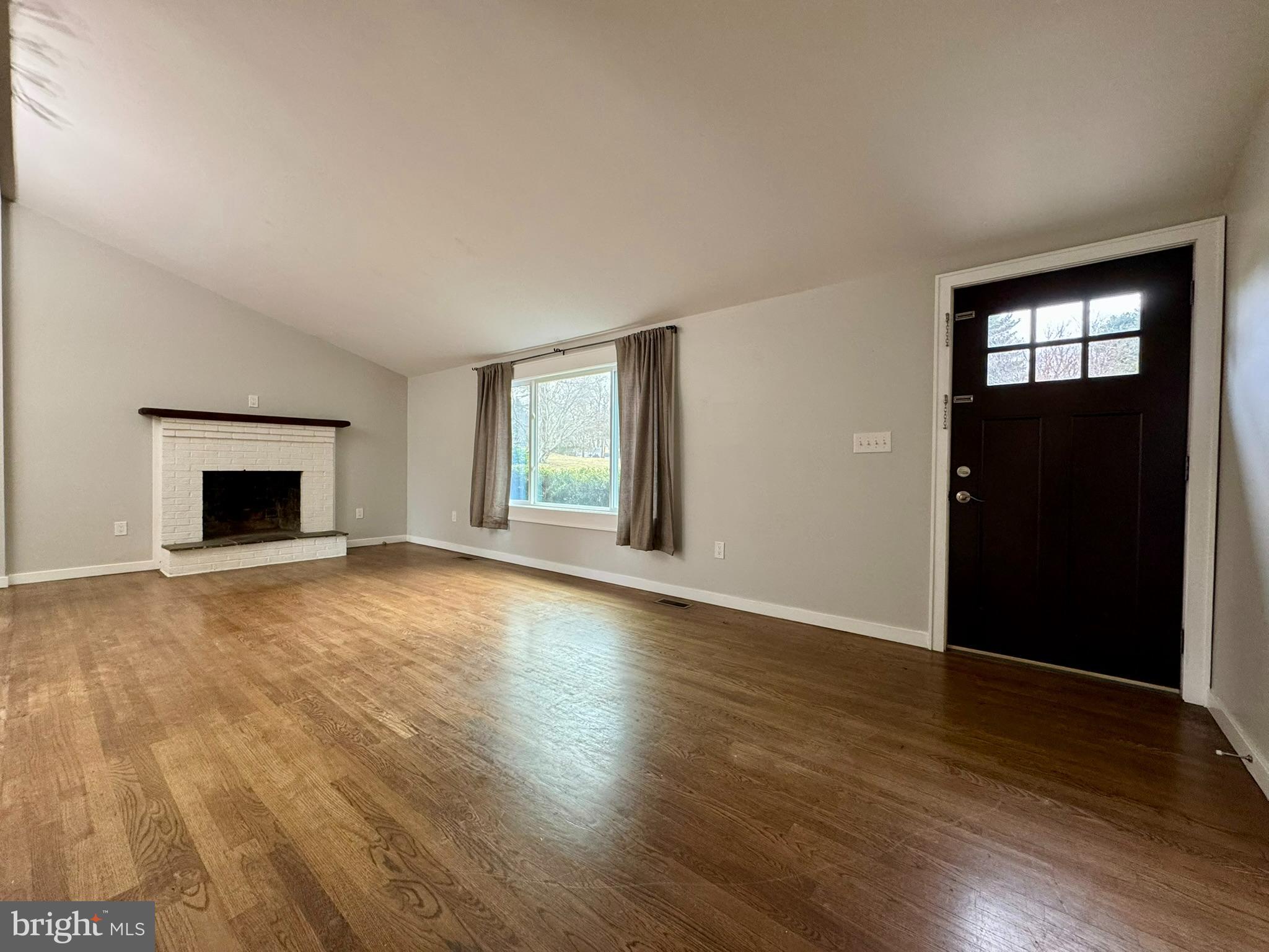 9813 Moyer Road Damascus, MD 20872 - Photo 3 of 31 a view of empty room with wooden floor and fireplace