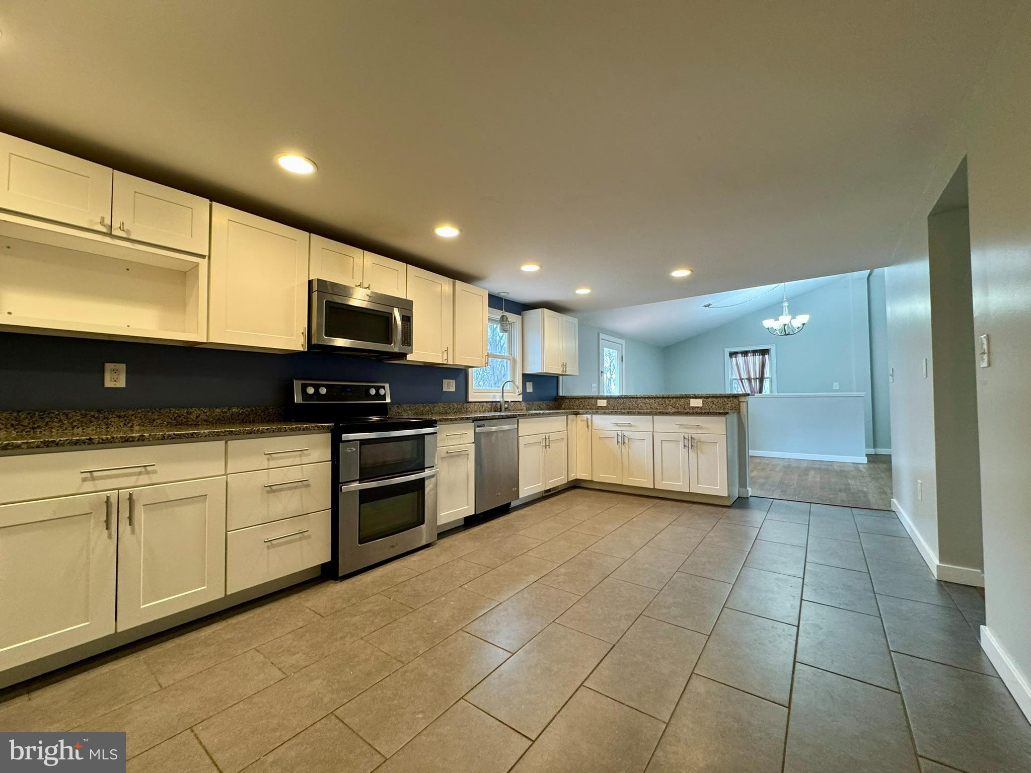 9813 Moyer Road Damascus, MD 20872 - Photo 9 of 31 a kitchen with stainless steel appliances granite countertop a sink a stove top oven and cabinets