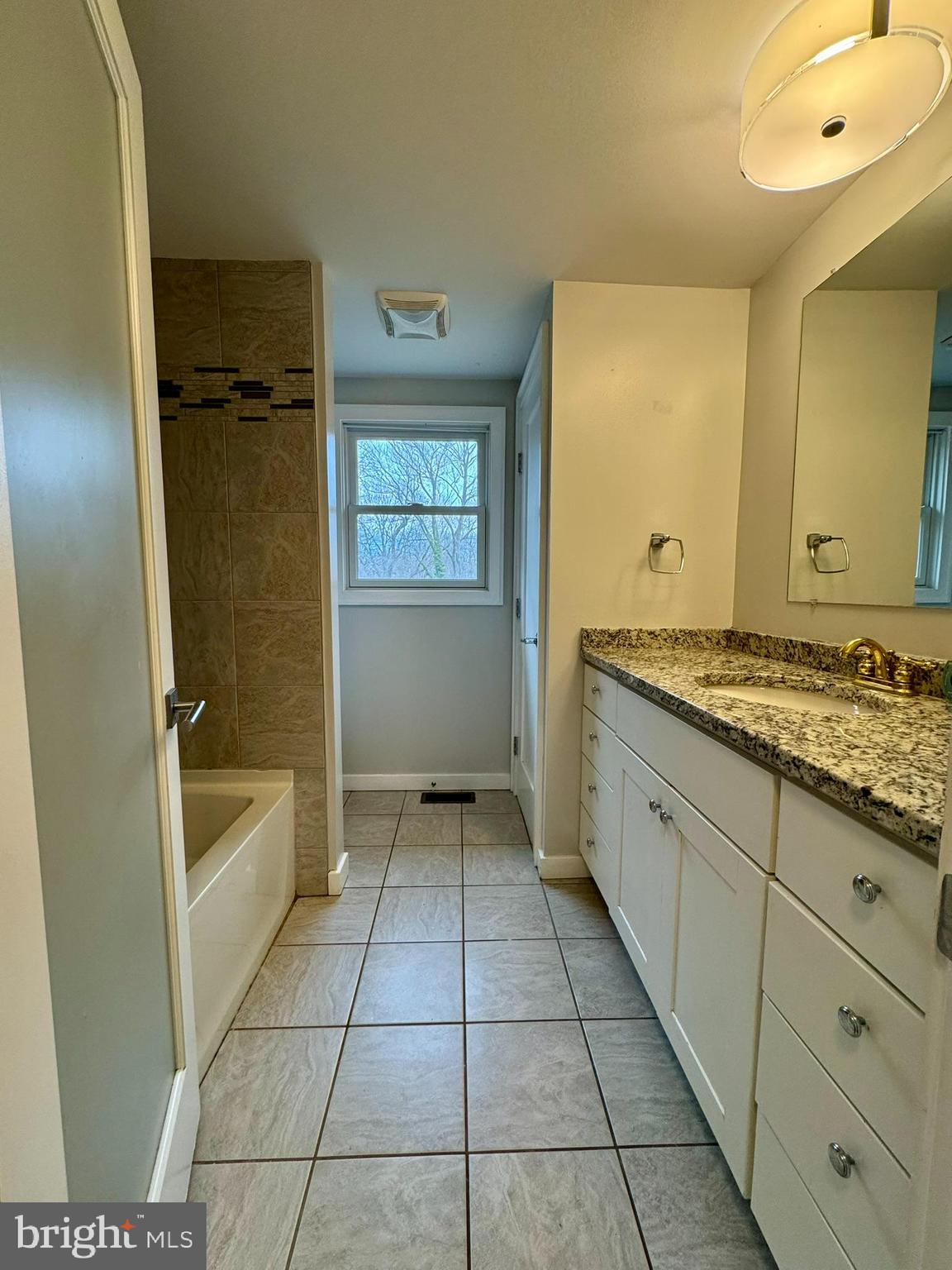 9813 Moyer Road Damascus, MD 20872 - Photo 10 of 31 a spacious bathroom with a granite countertop sink and a mirror