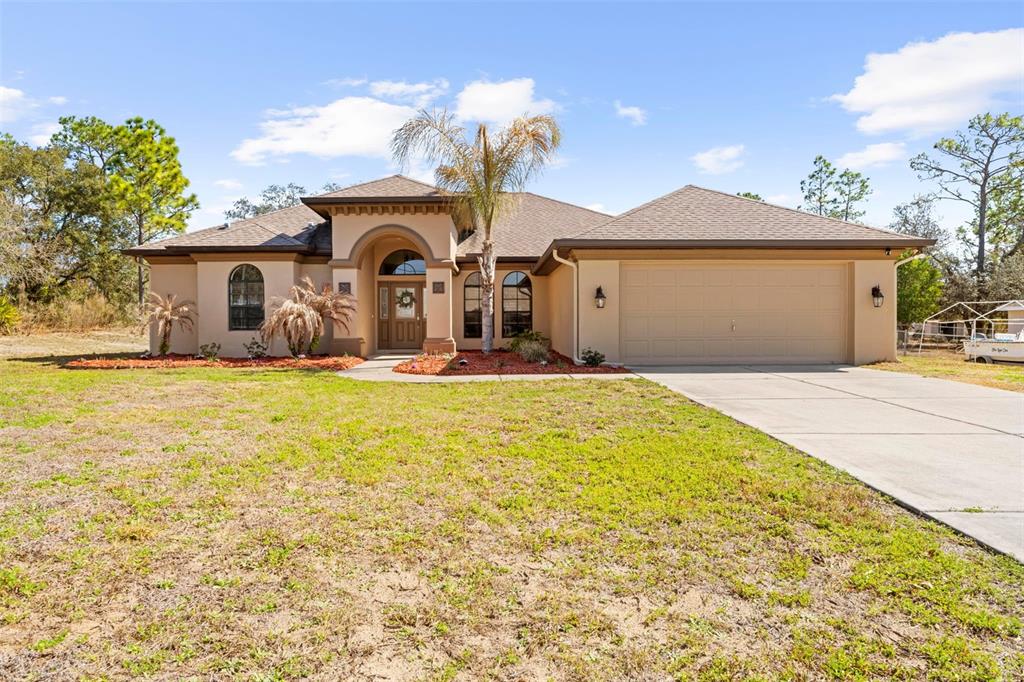 11014 Wren Road Brooksville, FL 34613 - Photo 1 of 50 a front view of a house with a yard and garage