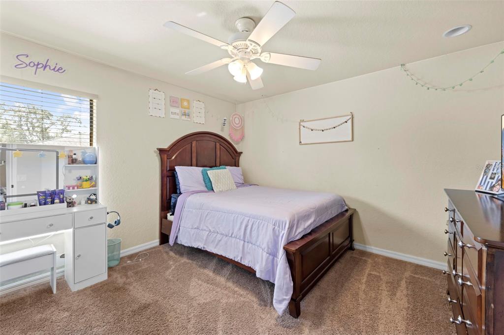 11014 Wren Road Brooksville, FL 34613 - Photo 28 of 50 a bedroom with a bed and a chandelier