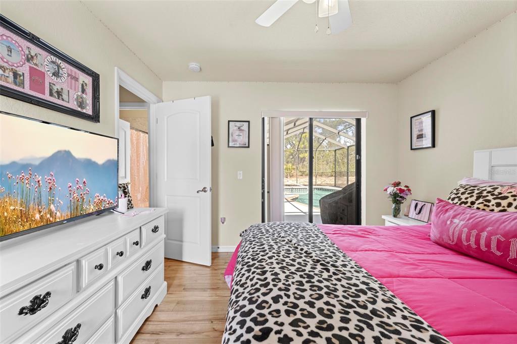 11014 Wren Road Brooksville, FL 34613 - Photo 32 of 50 a bedroom with a large bed and a chandelier